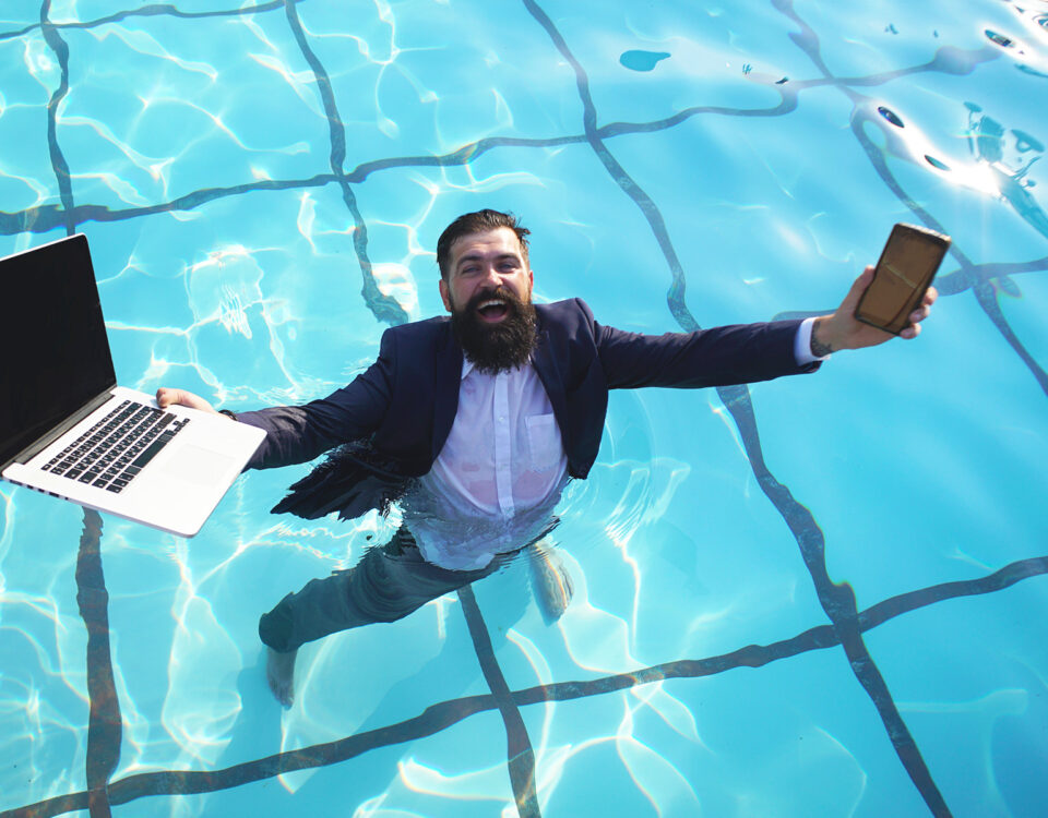 manažér pracujúci na notebooku v bazéne